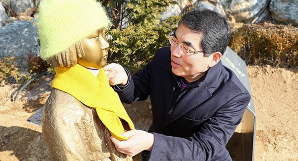 양기대 광명시장이 광명동굴 입구에 설치된 '광명 평화의 소녀상' 에 목도리를 둘러주고 있다