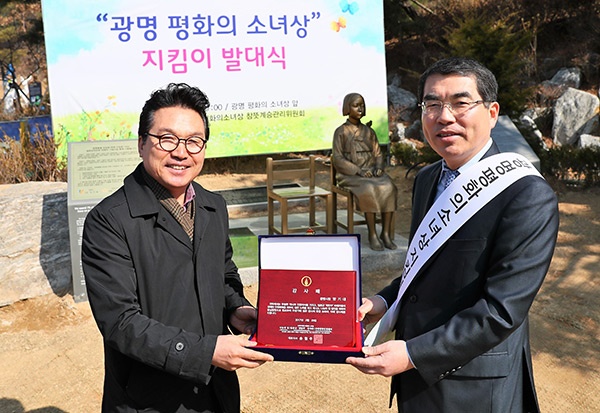 11일 광명동굴 입구에서 열린 '광명평화의 소녀상 지킴이' 발대식에서 양기대 광명시장이 광주 나눔의 집 안신권 소장에게 감사패를 받고 있다