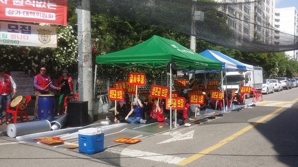 ▲ 안양시 비산2동 재건축지역 상가 세입자들이 재건축조합 사무실 인근에서 영업손실보상 등을 요구하며 시위를 벌이고 있다.