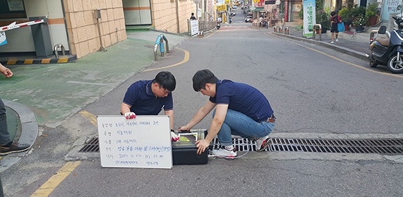 최근 악취 민원이 발생한 태평4동 금빛초등학교 주변 하수구에서 시료를 채취하고 있다