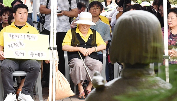 위안부 기림일 행사에 참석한 안점순 할머니(흰색 모자 쓴 사람)가 참가자들의 발언을 듣고 있다